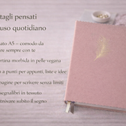 Taccuino rosa elegante con copertina in pelle vegana e bordi ondulati, appoggiato su una superficie chiara. A sinistra testo overlay con caratteristiche del prodotto: formato A5, carta a punti, 240 pagine e doppio segnalibro in tessuto, pensato per l’uso quotidiano.