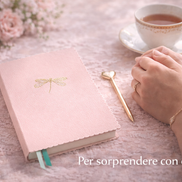 Taccuino A5 rosa con copertina morbida e dettagli dorati appoggiato su una scrivania, utilizzato da una donna in un contesto elegante e quotidiano.